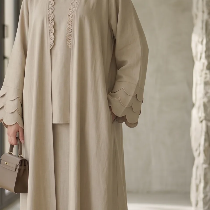 Scalloped edging along the sleeve and front opening of a sand abaya